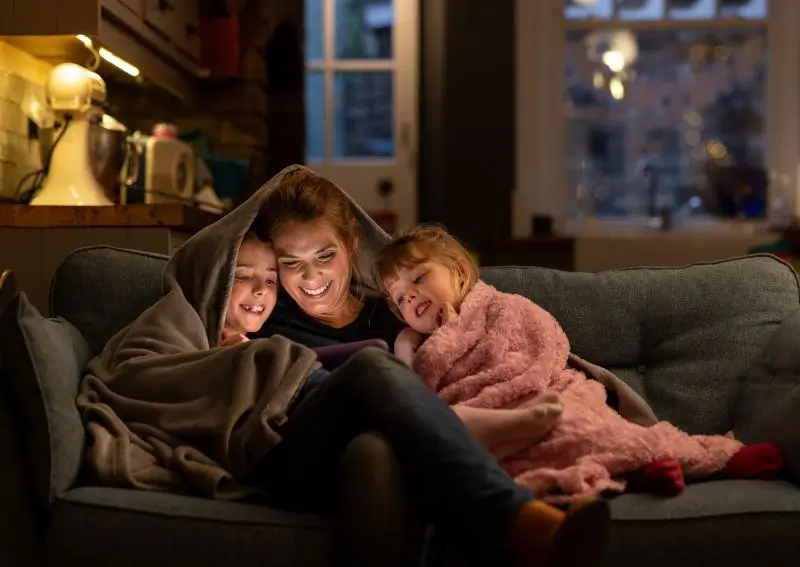 Family bundled up on the couch during a Texas winter.